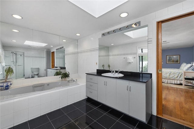 788 Namquid Dr, Warwick, RI 02888 - bathroom featuring vanity, a stall shower, a garden tub, tile patterned flooring, and a skylight
