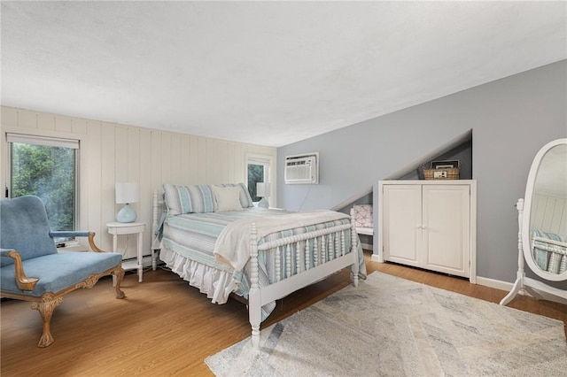 788 Namquid Dr, Warwick, RI 02888 - bedroom with multiple windows, a wall mounted AC, wood finished floors, and a baseboard heating unit