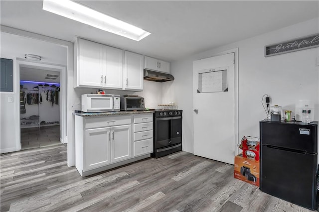 101 Benefit St, Pawtucket, RI 02860 - kitchen featuring black appliances, under cabinet range hood, white cabinetry, light wood-type flooring, and dark countertops