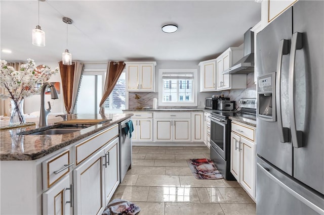 101 Benefit St, Pawtucket, RI 02860 - kitchen featuring appliances with stainless steel finishes, wall chimney exhaust hood, dark stone countertops, pendant lighting, and a kitchen island with sink