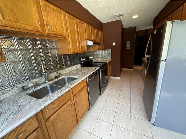 511 Child St Unit 101, Warren, RI 02885 - kitchen with stainless steel appliances, under cabinet range hood, backsplash, light tile patterned flooring, and a textured ceiling