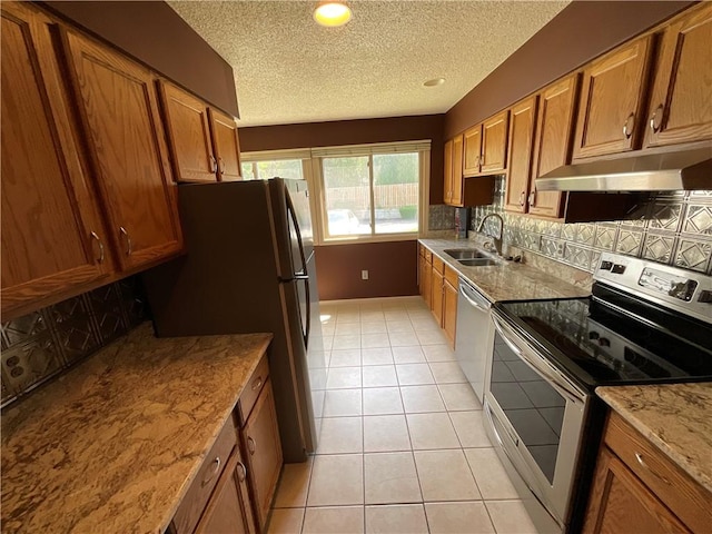 511 Child St Unit 101, Warren, RI 02885 - kitchen with appliances with stainless steel finishes, under cabinet range hood, brown cabinets, light tile patterned flooring, and backsplash