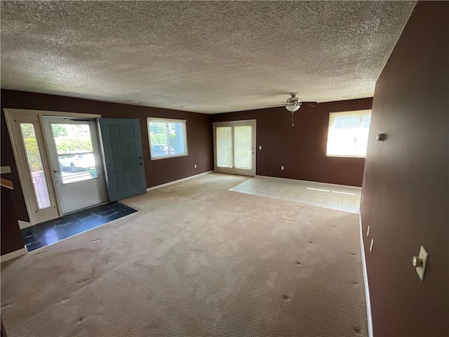 511 Child St Unit 101, Warren, RI 02885 - unfurnished living room with plenty of natural light, carpet floors, a ceiling fan, and a textured ceiling