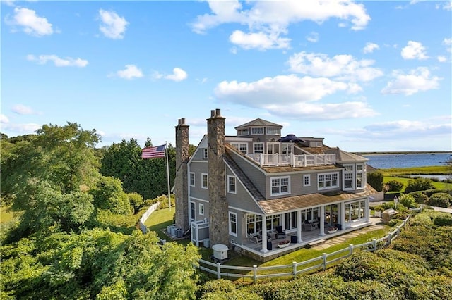 9 Arraquat Rd, Westerly, RI 02891 - rear view of property featuring a water view, a fenced backyard, a chimney, and a balcony