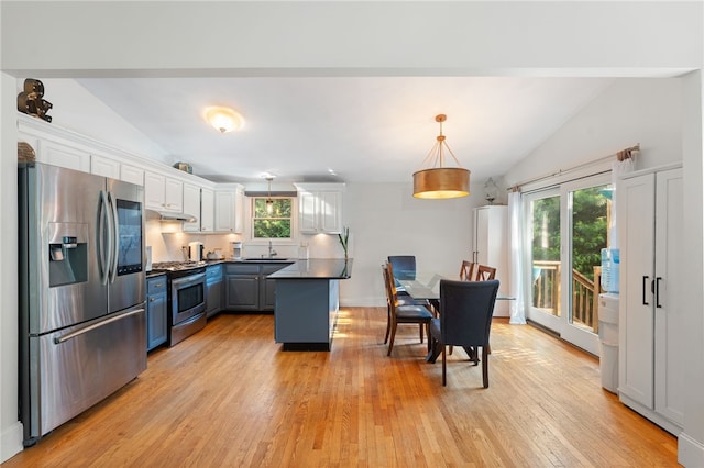 11 Burr Ave, Barrington, RI 02806 - kitchen featuring stainless steel appliances, vaulted ceiling, under cabinet range hood, light wood-type flooring, and white cabinetry