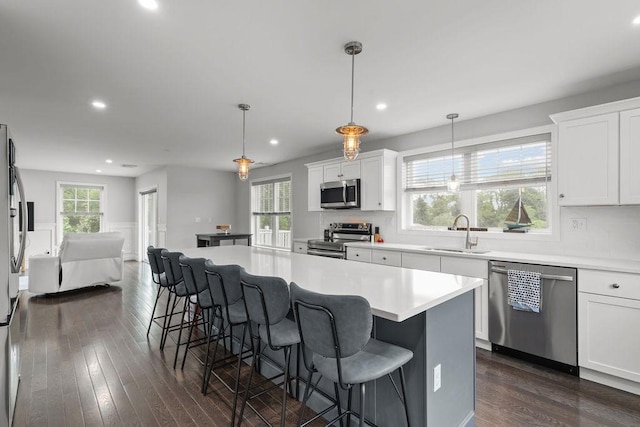 15 Spadina Ave, Warwick, RI 02889 - kitchen featuring appliances with stainless steel finishes, dark wood-style flooring, a breakfast bar area, open floor plan, and recessed lighting