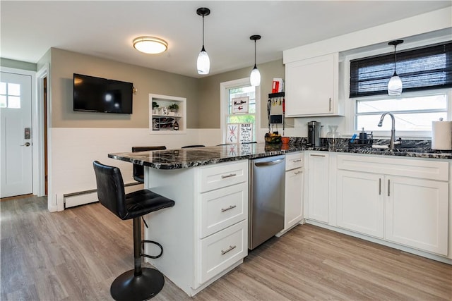 111 Belgium St, Cranston, RI 02920 - kitchen with stainless steel dishwasher, a peninsula, white cabinetry, light wood-type flooring, and a wainscoted wall