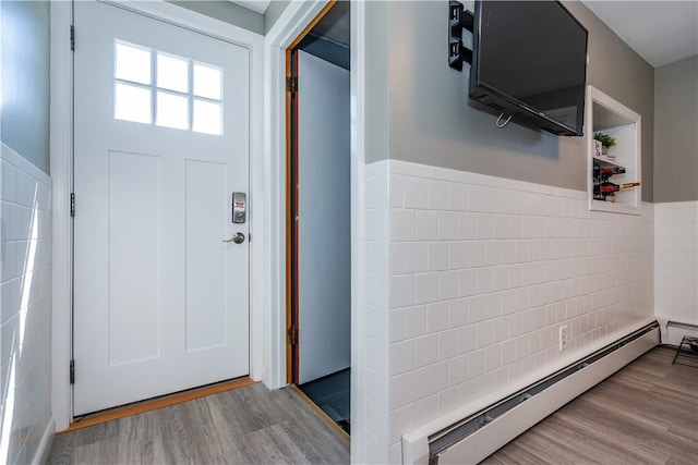 111 Belgium St, Cranston, RI 02920 - foyer with a baseboard heating unit, a wainscoted wall, wood finished floors, and tile walls