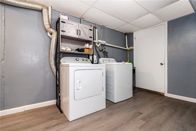 111 Belgium St, Cranston, RI 02920 - laundry area featuring washing machine and clothes dryer, light wood-style flooring, and cabinet space