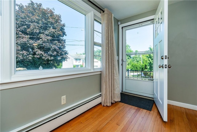 111 Belgium St, Cranston, RI 02920 - doorway with a baseboard heating unit and light wood-style floors