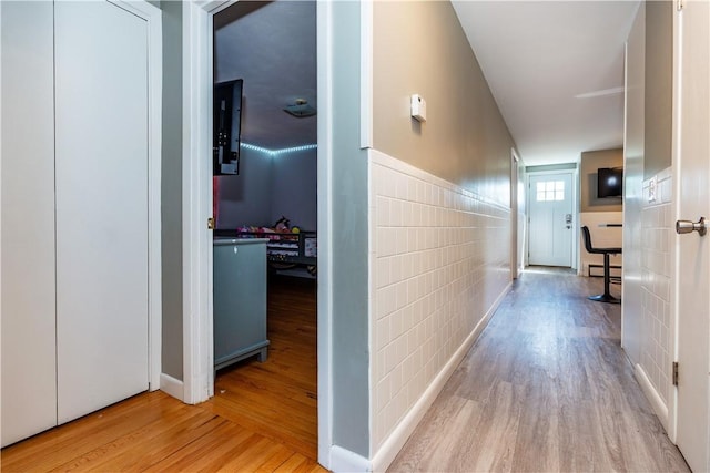 111 Belgium St, Cranston, RI 02920 - hallway featuring tile walls, wood finished floors, a wainscoted wall, and a baseboard heating unit