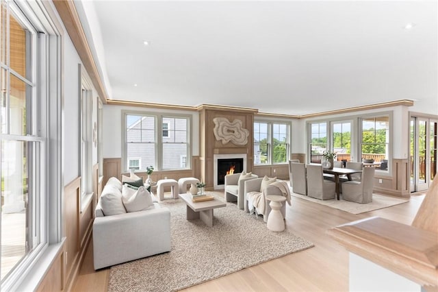 35 Coggeshall Ave, Newport, RI 02840 - living area featuring a lit fireplace, light wood-type flooring, and a wainscoted wall