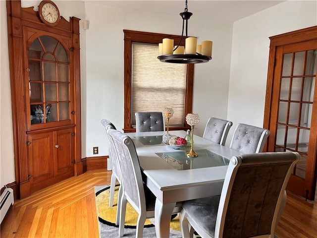 11 Potter Ave, West Warwick, RI 02893 - dining area featuring light wood-style flooring and a baseboard heating unit