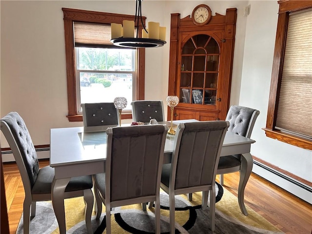 11 Potter Ave, West Warwick, RI 02893 - dining space with wood finished floors, a baseboard heating unit, and a chandelier