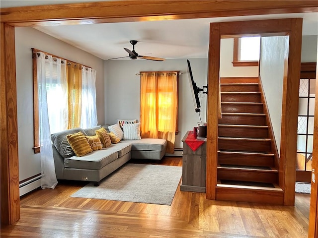 11 Potter Ave, West Warwick, RI 02893 - living area with a baseboard heating unit, a ceiling fan, wood finished floors, and stairs