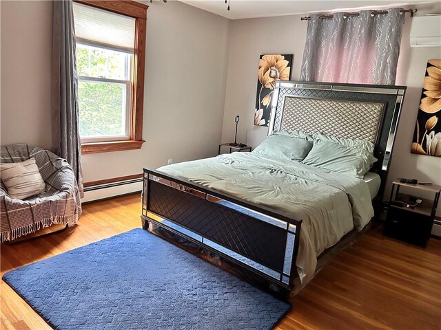 11 Potter Ave, West Warwick, RI 02893 - bedroom featuring a baseboard heating unit, wood finished floors, and a wall mounted AC