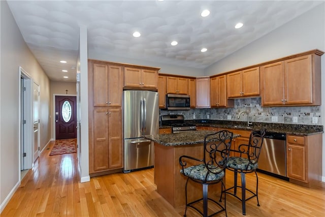 1285 Hartford Ave Unit 25, Johnston, RI 02919 - kitchen with stainless steel appliances, light wood-type flooring, tasteful backsplash, a center island, and recessed lighting