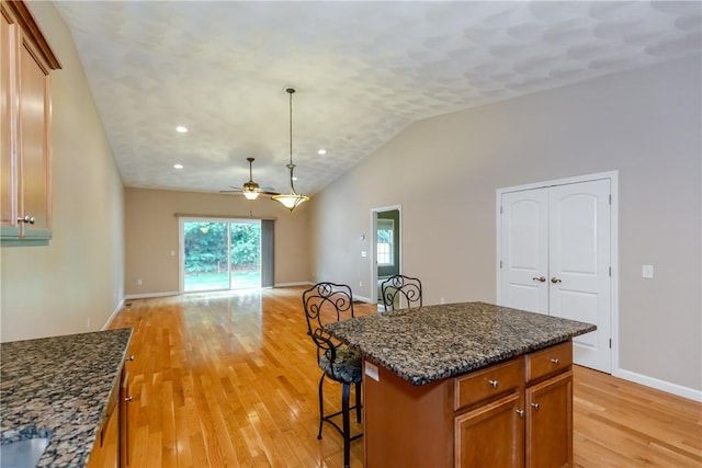 1285 Hartford Ave Unit 25, Johnston, RI 02919 - kitchen with ceiling fan, light wood finished floors, brown cabinets, a breakfast bar, and open floor plan