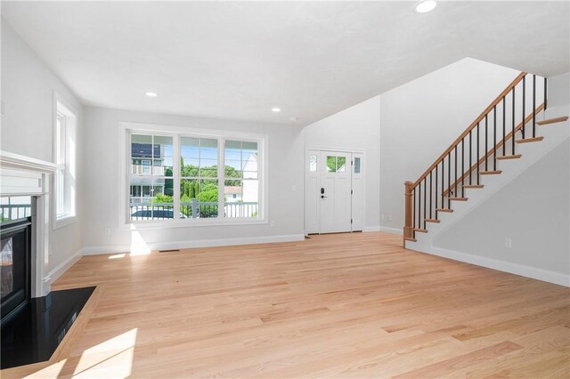 52 Governor St, Cumberland, RI 02864 - foyer entrance with stairs, a glass covered fireplace, light wood-style floors, and recessed lighting