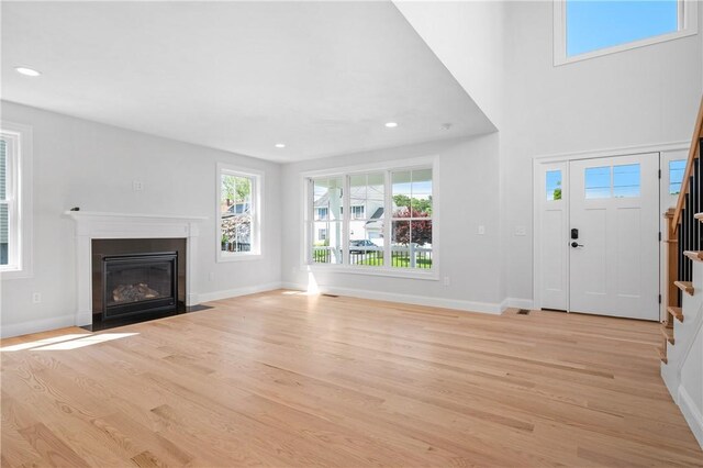 52 Governor St, Cumberland, RI 02864 - unfurnished living room with stairway, light wood-style floors, a fireplace with flush hearth, and recessed lighting