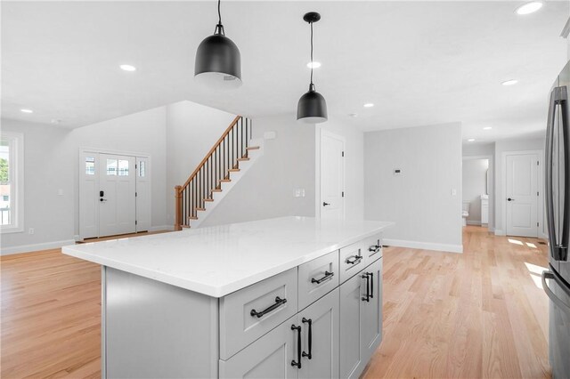 52 Governor St, Cumberland, RI 02864 - kitchen with light wood finished floors, decorative light fixtures, a kitchen island, recessed lighting, and freestanding refrigerator