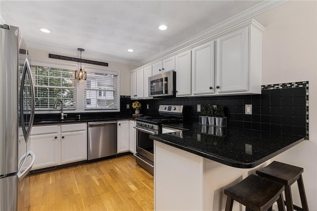 88 Red Brook Ln Unit 88, West Warwick, RI 02893 - kitchen with stainless steel appliances, a peninsula, crown molding, white cabinetry, and backsplash