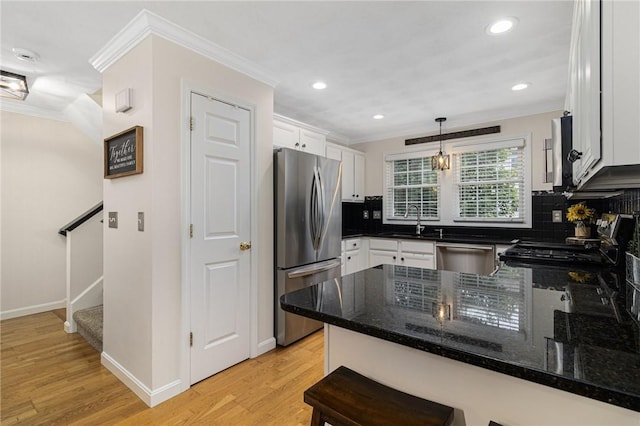 88 Red Brook Ln Unit 88, West Warwick, RI 02893 - kitchen featuring appliances with stainless steel finishes, crown molding, a peninsula, decorative backsplash, and light wood-style flooring