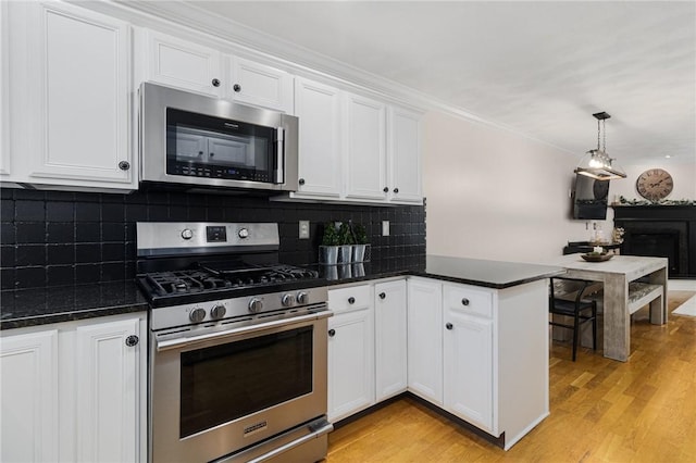 88 Red Brook Ln Unit 88, West Warwick, RI 02893 - kitchen featuring appliances with stainless steel finishes, light wood-style flooring, white cabinetry, decorative light fixtures, and decorative backsplash