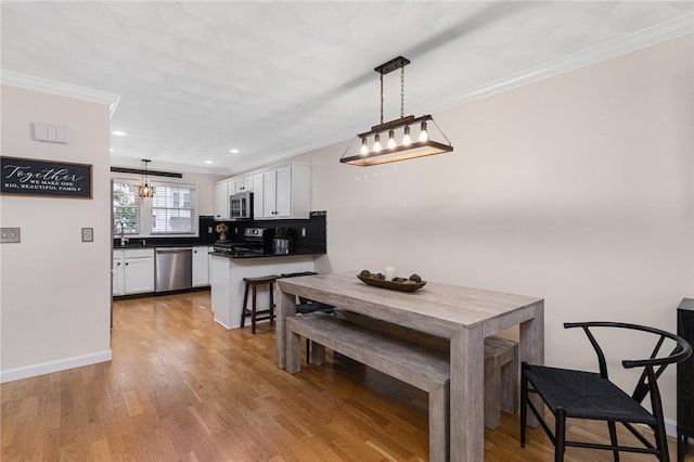 88 Red Brook Ln Unit 88, West Warwick, RI 02893 - kitchen with appliances with stainless steel finishes, white cabinets, ornamental molding, dark countertops, and a peninsula