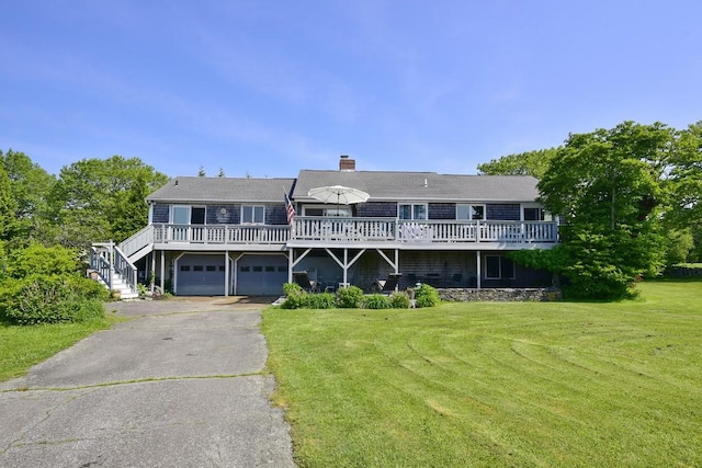 1 Butts Rock Rd, Little Compton, RI 02837 - view of front facade featuring asphalt driveway, a front yard, a wooden deck, an attached garage, and a chimney