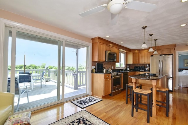 1 Butts Rock Rd, Little Compton, RI 02837 - kitchen featuring appliances with stainless steel finishes, light wood finished floors, a breakfast bar area, decorative light fixtures, and recessed lighting