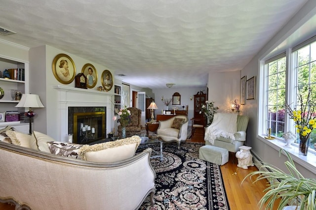 1 Butts Rock Rd, Little Compton, RI 02837 - living room featuring wood finished floors, a premium fireplace, and a textured ceiling