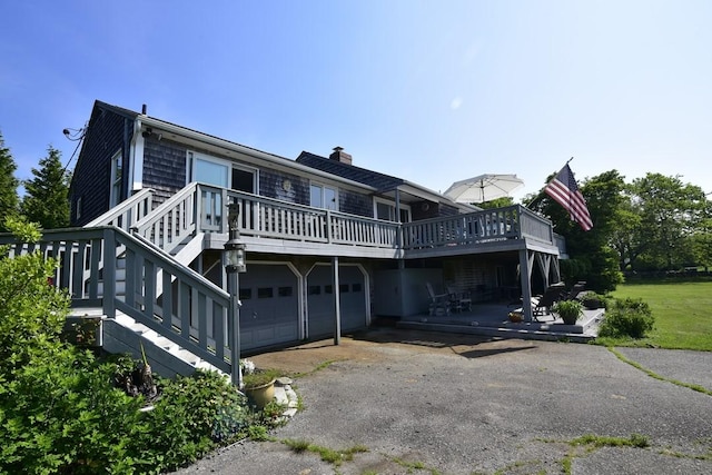 1 Butts Rock Rd, Little Compton, RI 02837 - rear view of property with a deck, a chimney, an attached garage, and asphalt driveway