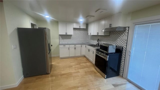 33 Williams St, New London, CT 06320 - kitchen featuring stainless steel appliances, under cabinet range hood, decorative backsplash, white cabinetry, and dark countertops