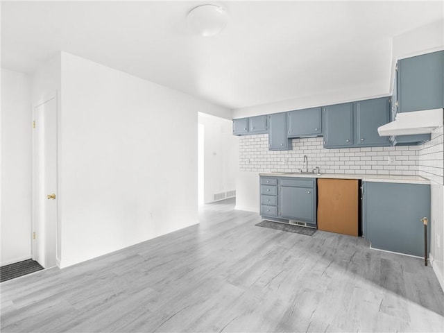 25 Martha Rd, East Providence, RI 02916 - kitchen with blue cabinets, light countertops, light wood finished floors, decorative backsplash, and custom exhaust hood