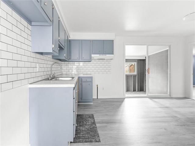 25 Martha Rd, East Providence, RI 02916 - kitchen with light wood-style flooring, under cabinet range hood, light countertops, tasteful backsplash, and blue cabinets