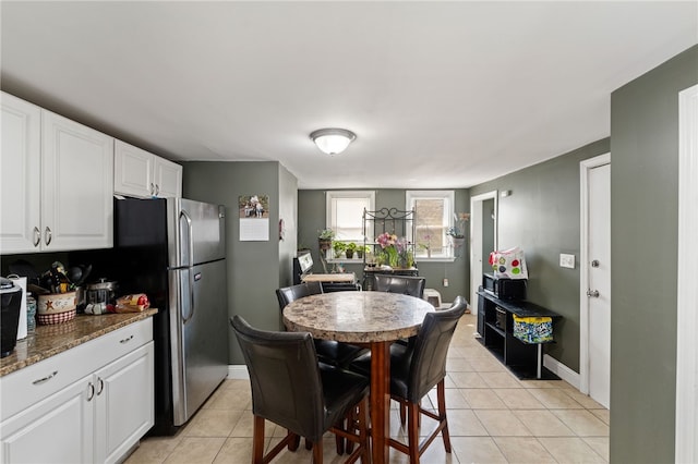313 Branch Ave, Providence, RI 02904 - kitchen with light tile patterned flooring, white cabinets, dark stone countertops, and freestanding refrigerator