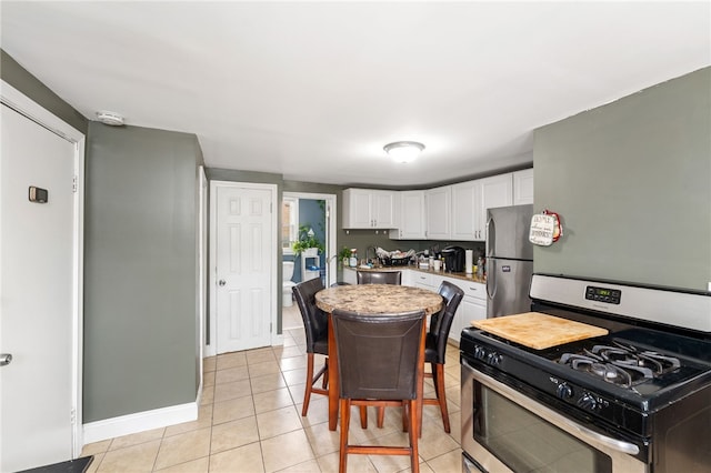 313 Branch Ave, Providence, RI 02904 - kitchen with appliances with stainless steel finishes, white cabinets, light tile patterned floors, and light countertops