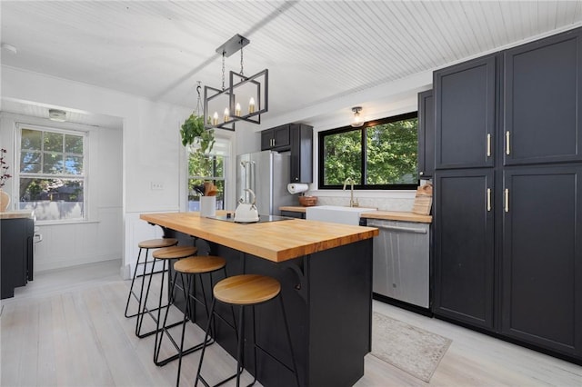 110 Spofford Ave, Warwick, RI 02888 - kitchen with wood counters, stainless steel appliances, a kitchen breakfast bar, healthy amount of natural light, and a wainscoted wall