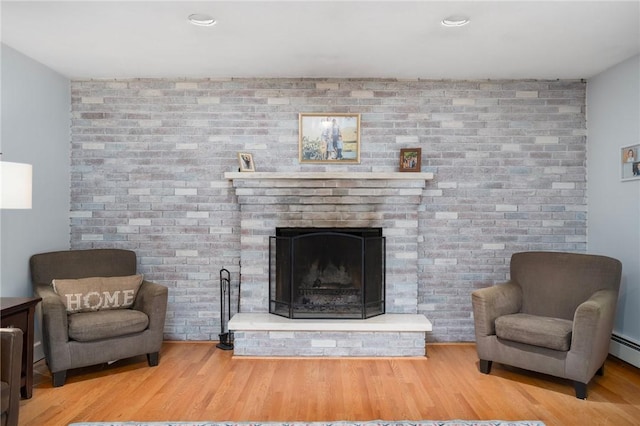 350 Shippee Rd, East Greenwich, RI 02818 - living area featuring a brick fireplace, wood finished floors, and brick wall