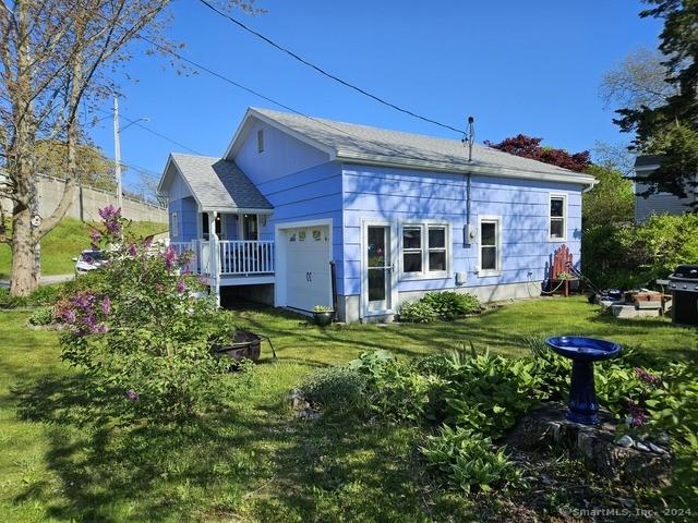 19 Lindberg Rd, Stonington, CT 06378 - back of property featuring a yard, an attached garage, and roof with shingles