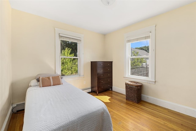 105 Overland Ave, Cranston, RI 02910 - bedroom featuring light wood-type flooring, baseboard heating, and a baseboard heating unit