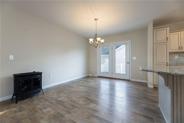 109 Chickadee Ln, South Kingstown, RI 02879 - unfurnished dining area with a wood stove, a chandelier, and wood finished floors