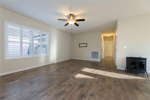 109 Chickadee Ln, South Kingstown, RI 02879 - unfurnished living room with a wood stove, a ceiling fan, and dark wood-style flooring