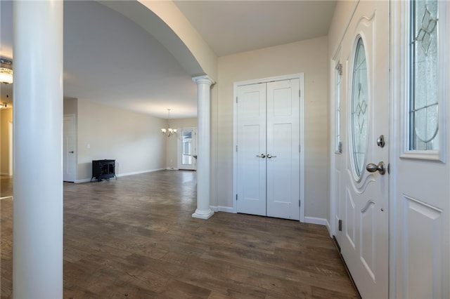 109 Chickadee Ln, South Kingstown, RI 02879 - foyer featuring dark wood-style flooring, arched walkways, decorative columns, and a wood stove