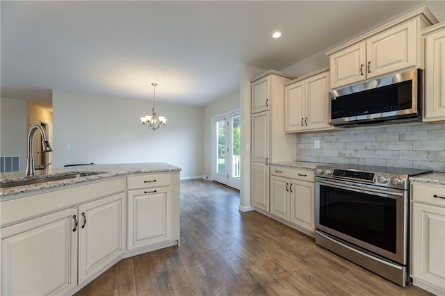 109 Chickadee Ln, South Kingstown, RI 02879 - kitchen with stainless steel appliances, light wood-type flooring, backsplash, a chandelier, and recessed lighting