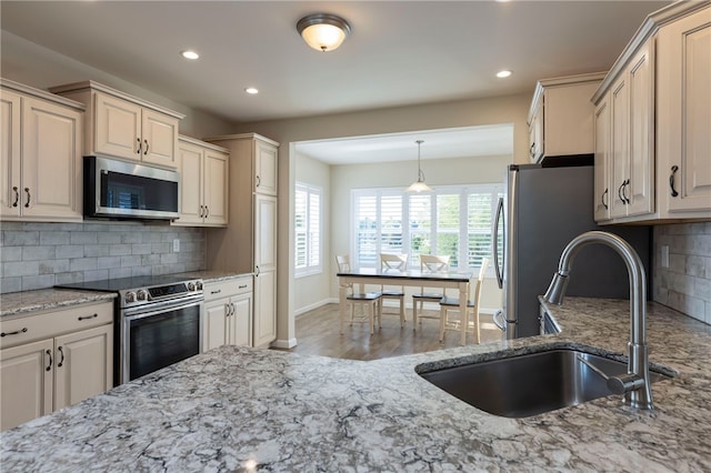 109 Chickadee Ln, South Kingstown, RI 02879 - kitchen featuring appliances with stainless steel finishes, light stone counters, recessed lighting, tasteful backsplash, and wood finished floors