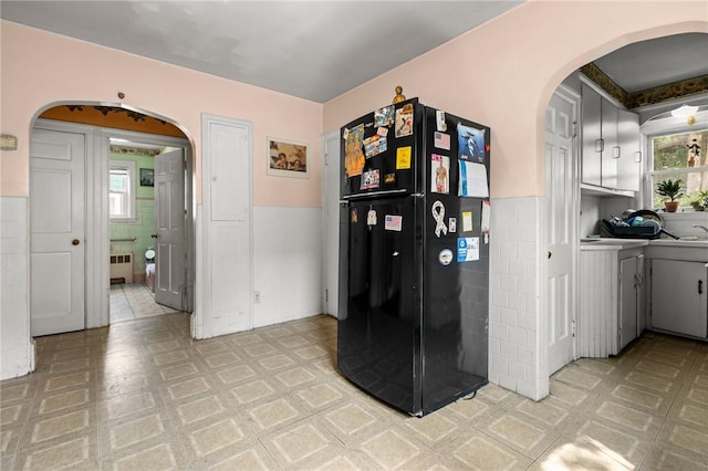 41 Higgins Ave, Providence, RI 02908 - dining area featuring arched walkways, tile walls, wainscoting, and radiator heating unit
