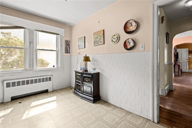 41 Higgins Ave, Providence, RI 02908 - interior space with radiator heating unit, arched walkways, tile walls, a wainscoted wall, and wood finished floors