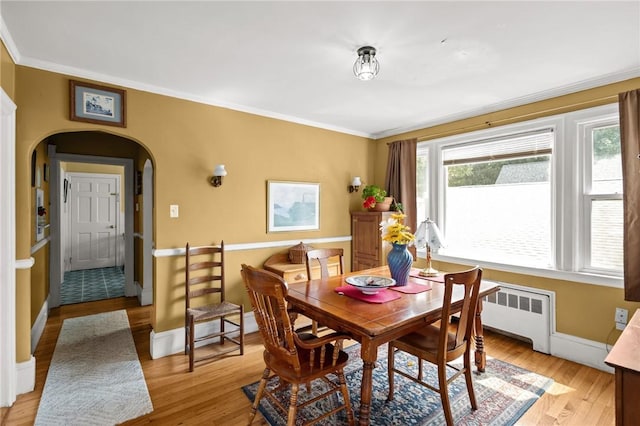 41 Higgins Ave, Providence, RI 02908 - dining area with arched walkways, ornamental molding, radiator, and light wood-style floors